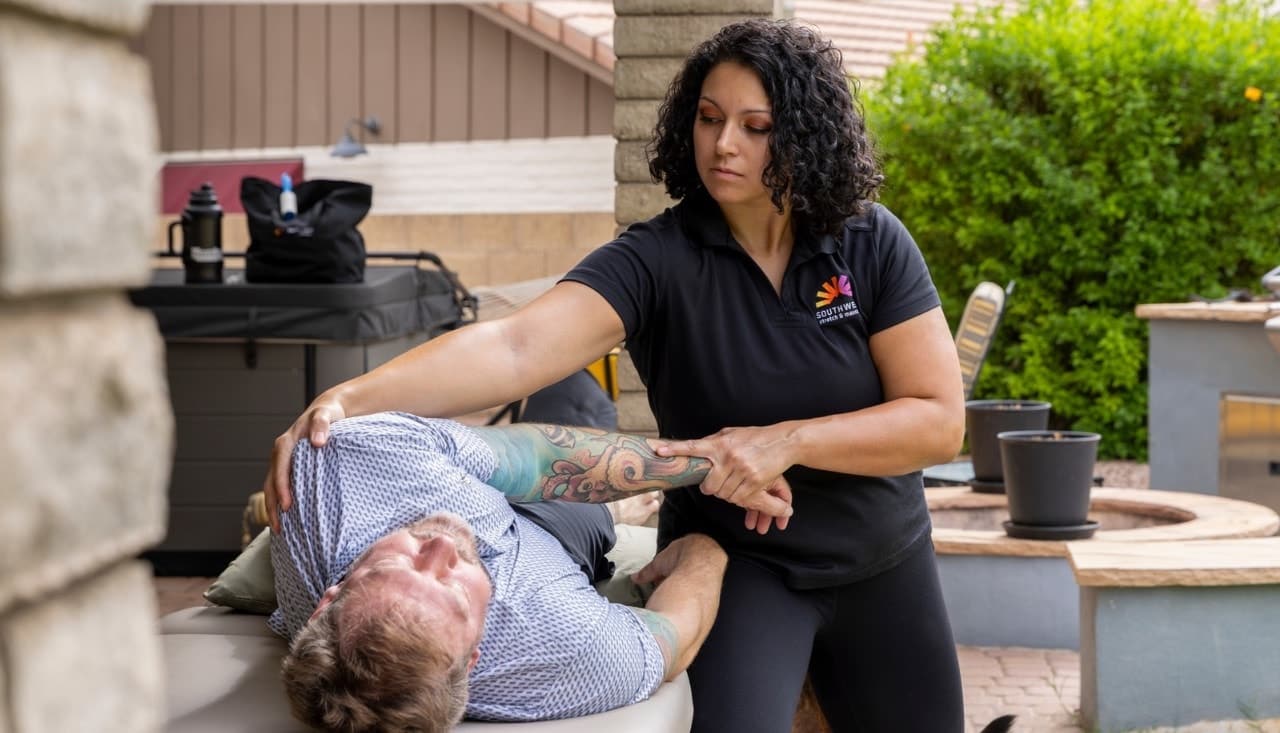 Therapist guiding an assisted shoulder stretch during an in-home session